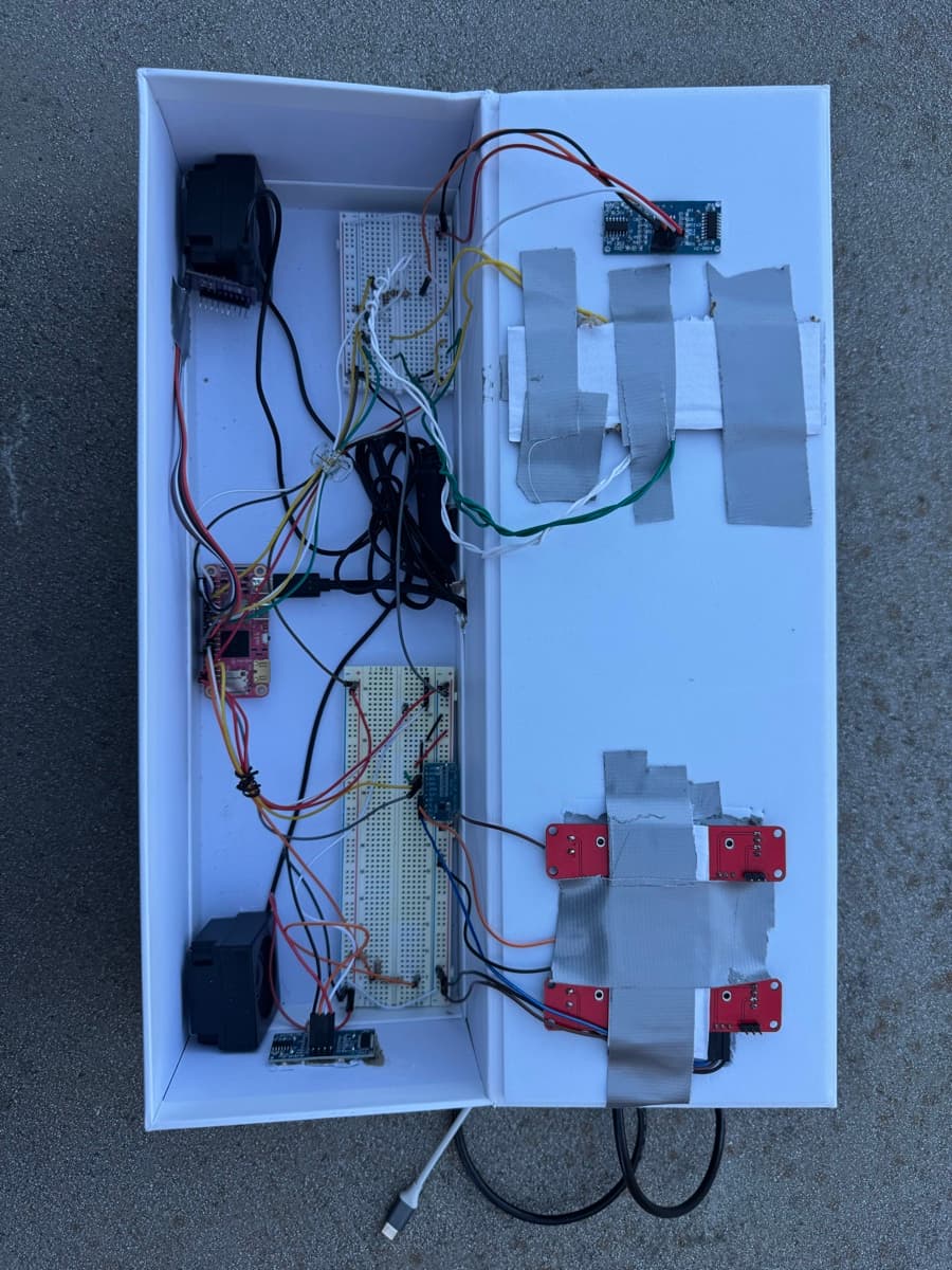 Inside the theremin: breadboards, a Mango Pi, two speakers, and ultrasonic sensors in a white box